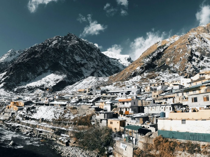 white and brown houses near mountain under blue sky during daytime