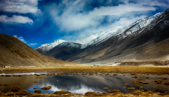 a mountain range with a lake in the foreground